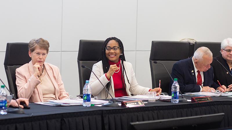 Malone sits with other board members